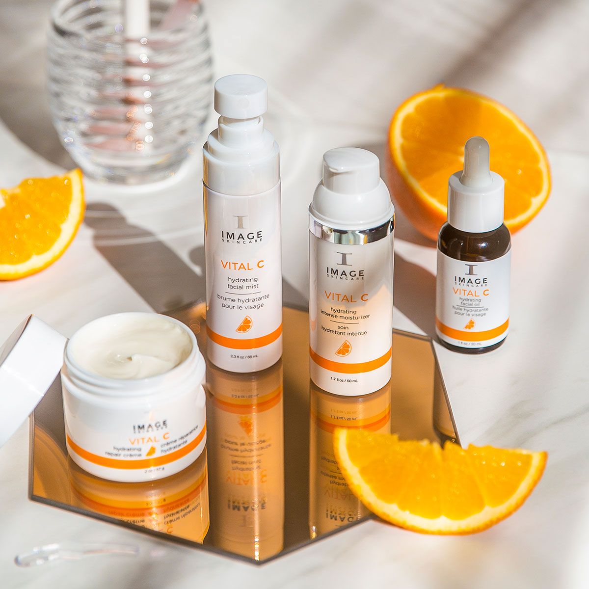 Several IMAGE Skincare products from the Vital C collection arranged on a tabletop with orange slices.